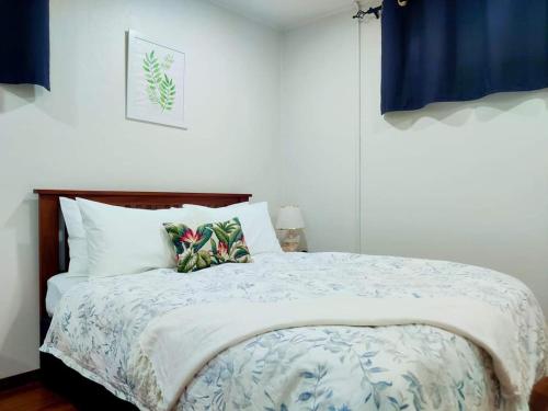 a bedroom with a bed with a blue and white comforter at Studio at Berry Road in Suva