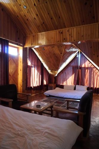 una habitación con 2 camas y una tienda de campaña en The Vintage Inn by suman cottage, en Manali