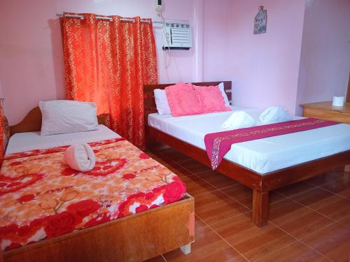 a room with two beds at JayDin Travellers Inn in Panglao