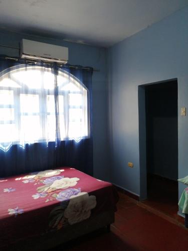 1 dormitorio con cama roja y ventana en Hotel 24/7 en Comayagua
