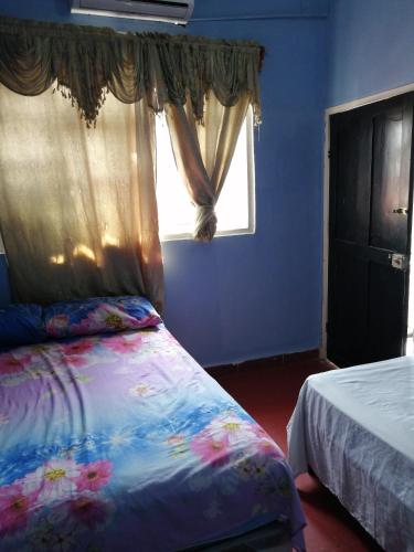Dormitorio azul con cama y ventana en Hotel 24/7 en Comayagua