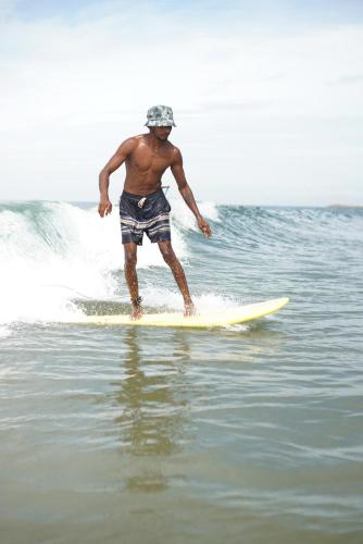 a man riding a wave on a surfboard in the water at Blue Lagoon Homestay in Mangalore