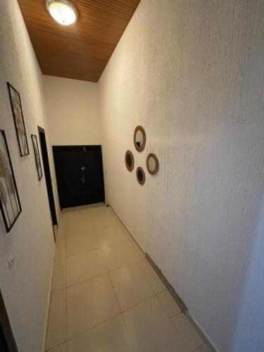 Ouidah的住宿－LOUKPEMI BUSINESS IL SARL，一条铺有白色地板和黑色门的走廊