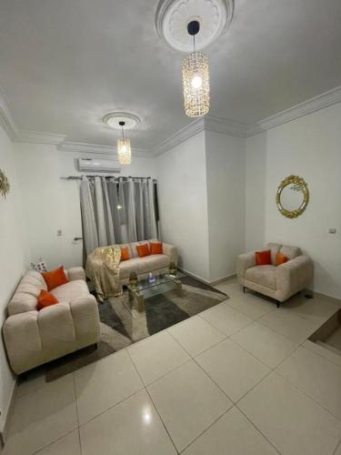 Sala de estar con 2 sofás y mesa en LOUKPEMI BUSINESS IL SARL, en Ouidah