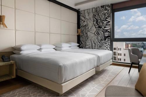 a bedroom with a large white bed and a window at Lagos Marriott Hotel Ikeja in Lagos