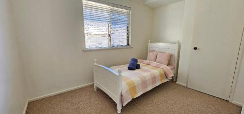 a small bedroom with a small bed with a blanket at Peaceful House in Perth
