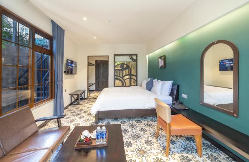 a hotel room with a bed and a couch at Brick House Dalat Hotel in Da Lat