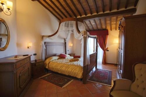 um quarto com uma cama de dossel e uma cómoda em Al Brunello em Montalcino