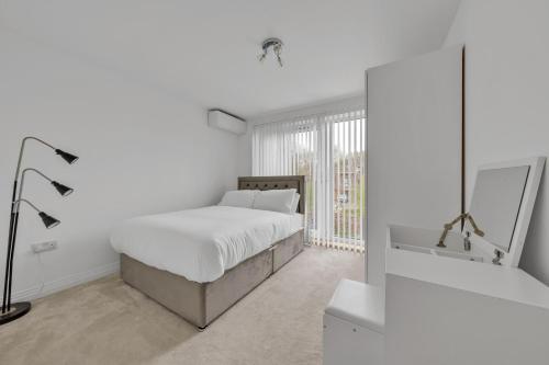 Habitación blanca con cama y ventana en 3 bedroom house in Bricket wood, St Alban en Garston