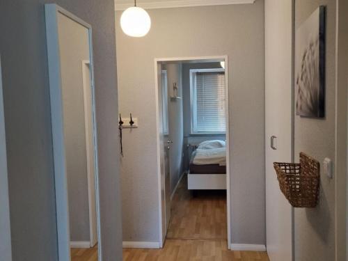 einen Flur mit einem Zimmer mit einem Bett und einer Tür in der Unterkunft Neuwerk Modern retreat in Wangerooge