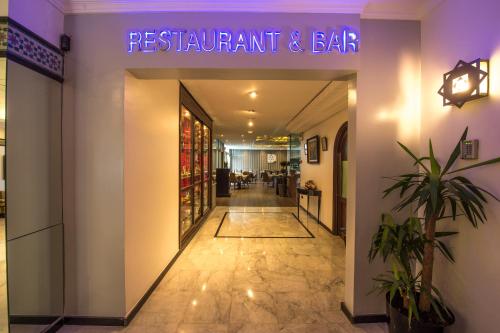 a restaurant and bar with a purple sign on the wall at Hotel Toubkal in Casablanca
