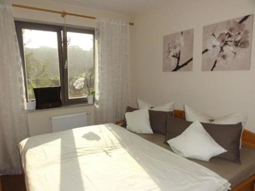- une chambre avec un grand lit et une fenêtre dans l'établissement Villa am Weinberg Waren, à Waren