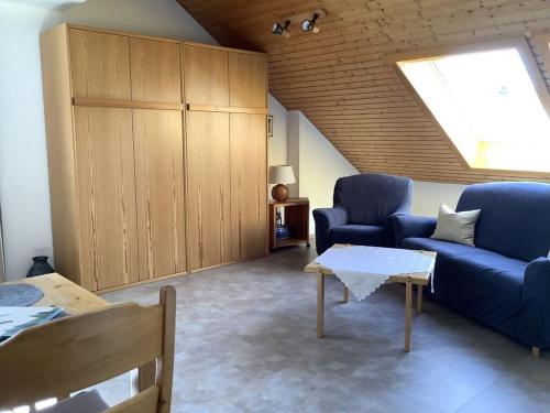 ein Wohnzimmer mit einem blauen Sofa und einem Tisch in der Unterkunft Haus Rieslehof Apartment 11 in Titisee-Neustadt