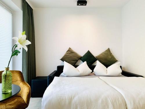 萬格羅格的住宿－Sea air Modern retreat，卧室配有一张白色的床,桌子上摆放着花瓶
