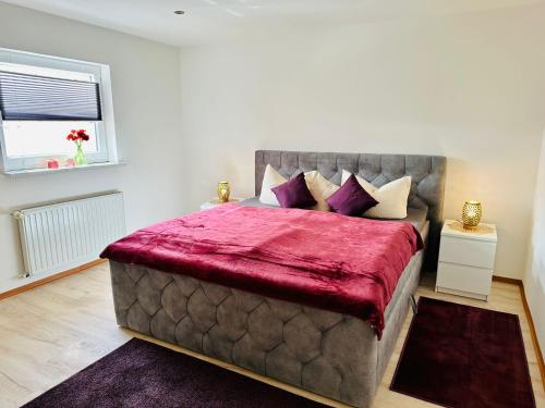 a bedroom with a large bed with a red blanket at Studio Reichenstrasse in Quedlinburg