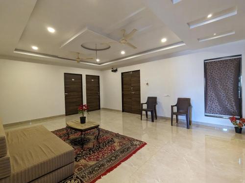 a living room with a couch and a table and chairs at Hotel and Villa Samarth Palace in Panchgani