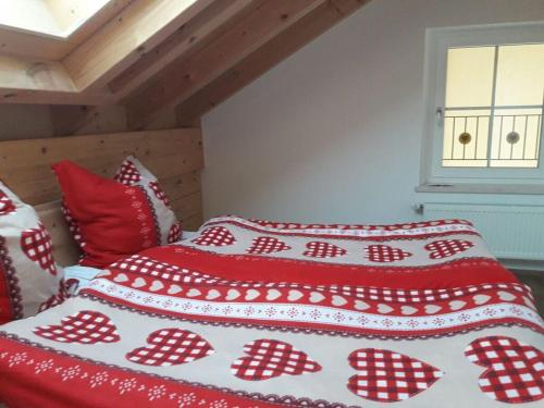 a bed with red and white blankets and pillows at Richter 2 Modern retreat in Wackersberg
