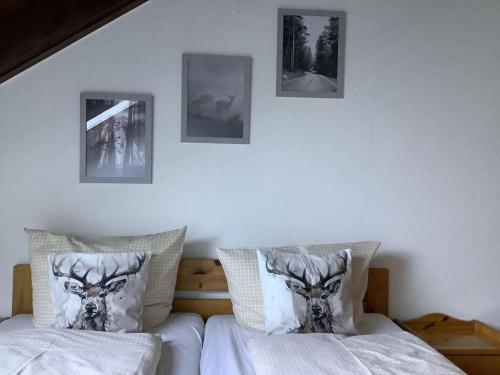 Huis Hochfirst Appartement 20 في تيتيسي نيوستادت: غرفة نوم بسريرين وصور على الحائط