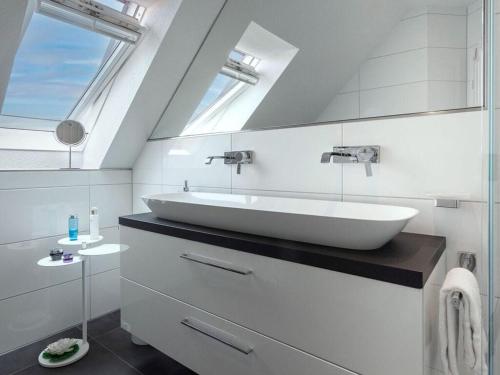 uma casa de banho com um grande lavatório branco e uma janela em Wild Duck Modern Retreat em Greetsiel