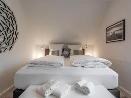 duas camas num quarto com toalhas numa mesa em Wild Duck Modern Retreat em Greetsiel