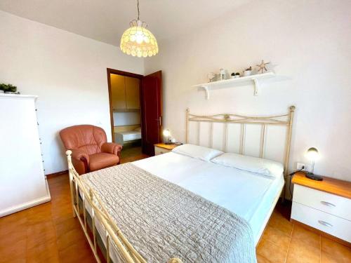 a bedroom with a bed and a chair at Inviting apartment by the beach in Porto Santa Margherita di Caorle