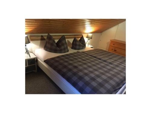 - une chambre avec un lit et des oreillers dans l'établissement Huis Rieslehof Appartement 12, à Titisee-Neustadt