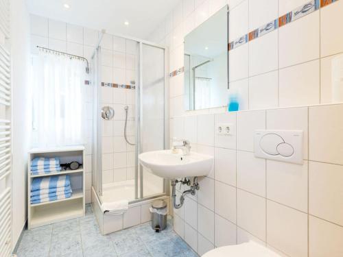 a white bathroom with a sink and a shower at Walnut Modern retreat in Hödingen