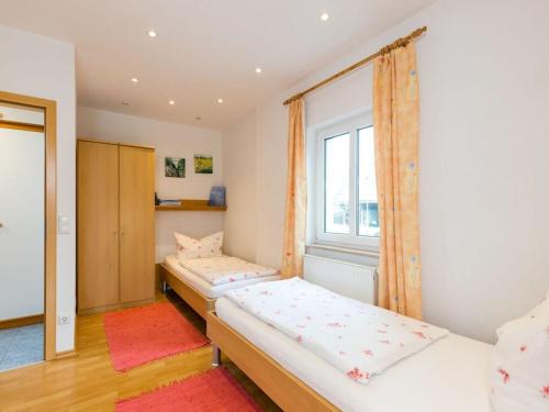 two beds in a room with a window at Walnut Modern retreat in Hödingen