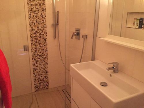 y baño con lavabo y ducha. en Ostbake Modern retreat en Wangerooge