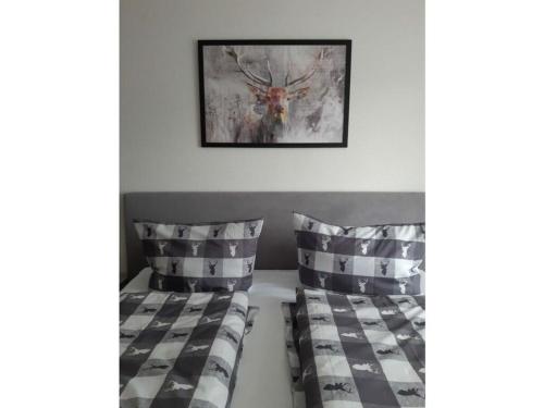 a bedroom with two beds and a picture of a deer at Huis Hochfirst Appartement 9 in Titisee-Neustadt