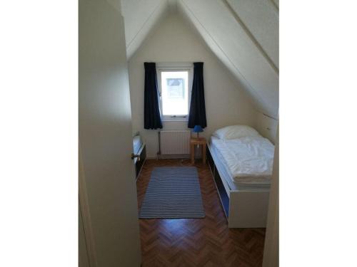 une petite chambre avec un lit et une fenêtre dans l'établissement Huijsmansverhuur Type B de Luxe Grevelingen 24, à Ouddorp