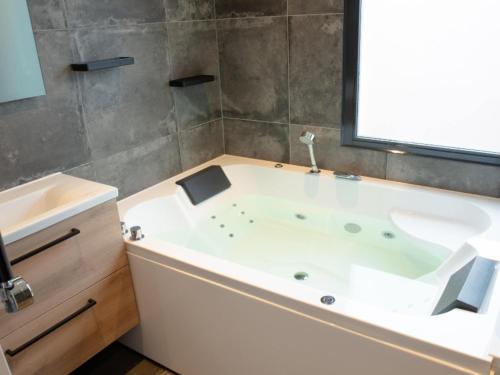 a white bath tub in a bathroom with a window at Holiday Home in Zevenhuizen with Sauna in Zevenhuizen