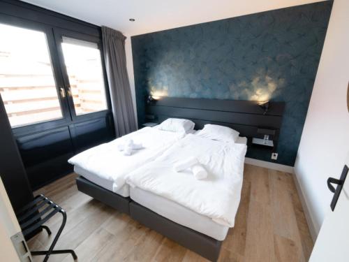 een slaapkamer met een groot bed met witte lakens bij Wellness Bungalow with whirlpool and sauna in Zevenhuizen