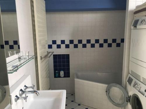 een badkamer met een bad, een wastafel en een spiegel bij Aan de Kade Modern retreat in Enkhuizen