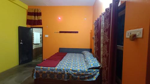 een klein bed in een kamer met gele muren bij Shail guest house in Ayodhya