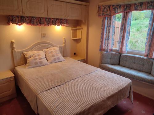 ein Schlafzimmer mit einem Bett, einem Stuhl und einem Fenster in der Unterkunft Domek letniskowy in Jeziorowskie