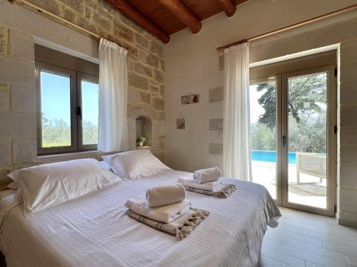 1 dormitorio con 1 cama grande y toallas. en Villa Olivia with Pool Vrises Crete en Alikampos