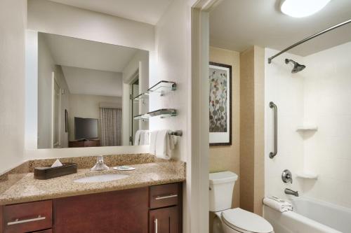 a bathroom with a sink and a toilet and a mirror at Residence Inn Jackson in Jackson