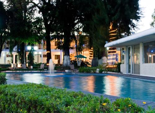 una piscina con una fuente frente a un edificio en Hotel Ronda Minerva, en Guadalajara