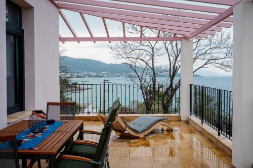 a patio with a table and chairs and a view of the water at Blue Crystal View in Kavala