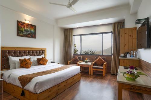 ein Hotelzimmer mit einem Bett und einem Fenster in der Unterkunft The Mountain Quail in Masuri