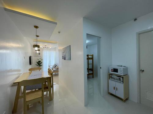 a kitchen and dining room with a table and a microwave at 2 BR Condo at Camella Manors Palawan in Puerto Princesa City
