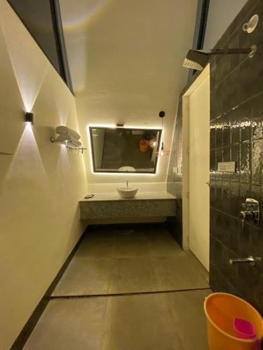 a bathroom with a sink and a mirror at NAMASTE BEACH RESORT in Jāmb