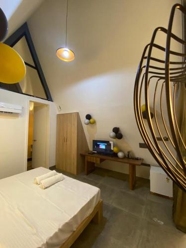 a bedroom with a bed and a desk with a laptop at NAMASTE BEACH RESORT in Jāmb