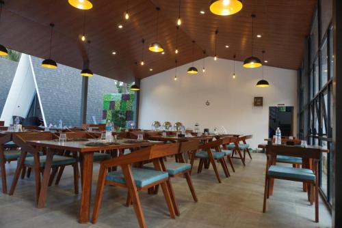 a large dining room with wooden tables and chairs at NAMASTE BEACH RESORT in Jāmb