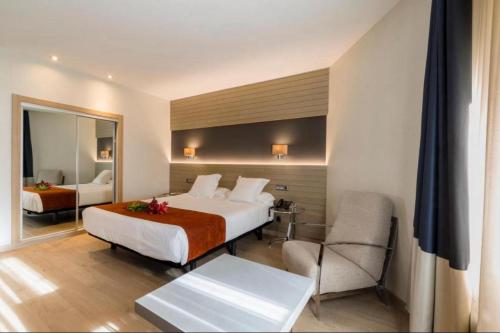 a hotel room with a bed and a chair at HOTEL AVENIDA 22 Sector de escenarios deportivos y clinicas in Santa Marta