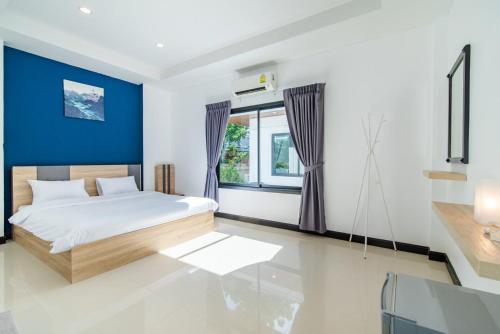 - une chambre avec un lit et un mur bleu dans l'établissement ZEN2 Pool Villa Hua Hin, à Hua Hin
