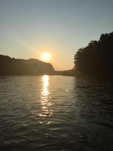 a sun setting over a body of water at Hotel Alpenblick in Riedering