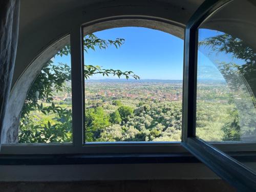 an arched window in a building with a view of trees at Hotel Villa Sermolli in Borgo a Buggiano