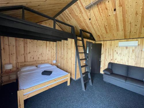 a bedroom with a bunk bed and a couch at СвояХата in Svityazʼ